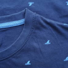 Load image into Gallery viewer, Je Moeder T-shirt met Blauw Haaienvinnen motief. Donkerblauw t-shirt met allover print van haaienvinnen en een witte opdruk van Moeder Aarde. Foto van hals boord en haaienvinnen print.